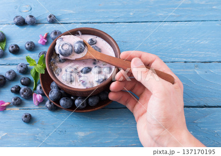 The man is having breakfast. Spoon in hand. 137170195