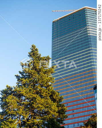 Modern construction of a high-rise building. Modern architecture of a business center. Apartment in a high-rise building. 137170242