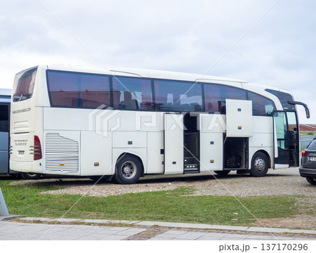 A Mercedes Benz bus is preparing to depart. Loading things onto the bus. Motor transport industry. Open doors 137170296