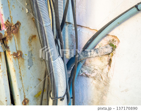 Electrical wiring on the wall outside. Sheathed wires. Energy supply for houses. Electrification. Modern technologies. Electrical wiring on the wall outside. Sheathed wires. Energy supply for houses. Electrification. Modern technologies. 137170890