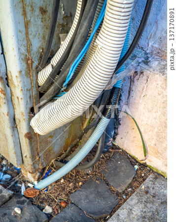 Electrical wiring on the wall outside. Sheathed wires. Energy supply for houses. Electrification. Modern technologies. Vintage. Electrical wiring on the wall outside. Sheathed wires. Energy supply for houses. Electrification. Modern technologies. Vintage. 137170891