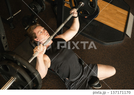 Man performing incline bench press with barbell Man performing incline bench press with barbell 137171170