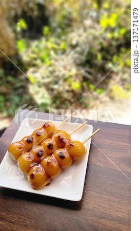 白い皿に盛られたみたらし団子　三つ 137171479