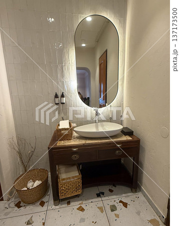 Stylish sink on wooden vanity in restroom interior. Cleanliness, design harmony, and comfort in modern hospitality environment. Stylish sink on wooden vanity in restroom interior. Cleanliness, design harmony, and comfort in modern hospitality environment. 137173500