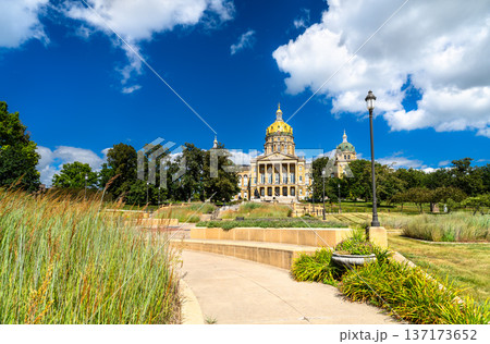 Iowa State Capitol building stands on a hill in Des Moines, USA. Historic architecture features a central golden dome and four corner domes under a blue summer sky 137173652