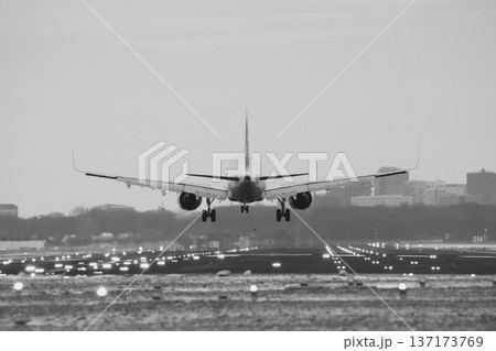 Black and white shot of an aircraft approaching the runway at an international airport Black and white shot of an aircraft approaching the runway at an international airport 137173769