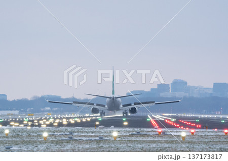 Passenger plane slowing down on airport landing strip with spoilers deployed in winter Passenger plane slowing down on airport landing strip with spoilers deployed in winter 137173817