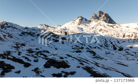 High altitude view of white snow fields leading to a distinctive rocky mountain peak 137173966