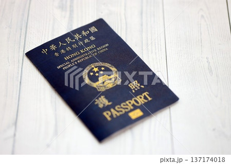 Hong Kong Special Administrative Region HKSAR Passport lies on wooden table background close up. Hong Kong blue new passport book in details Hong Kong Special Administrative Region HKSAR Passport lies on wooden table background close up. Hong Kong blue new passport book in details 137174018