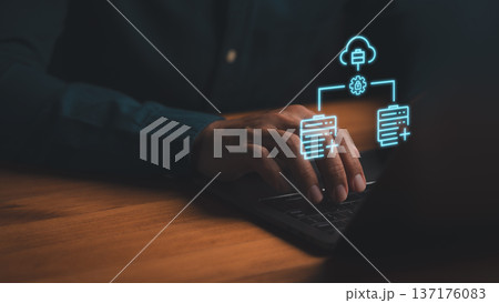 Cloud computing and database management concept. Person using laptop with glowing blue hologram icons of data server, cloud storage, and secure network connection. 137176083