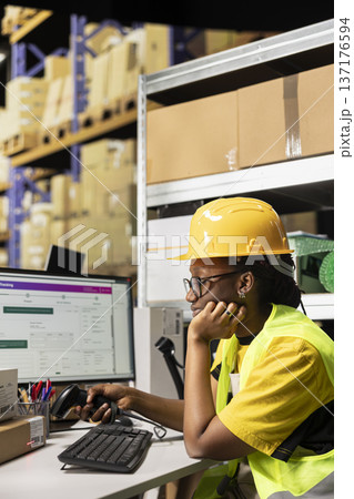 Exhausted female staff with helmet falling asleep scanning barcodes at desk, working on registering shipping labels and feeling overworked in the warehouse. Deals with burnout on the job. Exhausted female staff with helmet falling asleep scanning barcodes at desk, working on registering shipping labels and feeling overworked in the warehouse. Deals with burnout on the job. 137176594