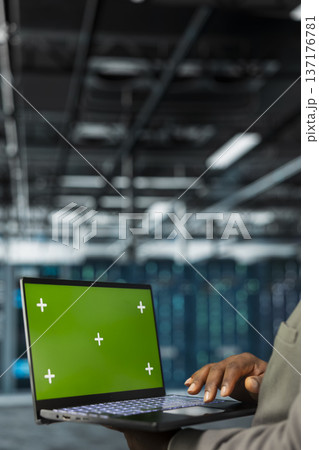 Close up of technician using green screen laptop in data center, managing rackmounts systems. Server hub employee using mockup notebook, installing upgraded infrastructure Close up of technician using green screen laptop in data center, managing rackmounts systems. Server hub employee using mockup notebook, installing upgraded infrastructure 137176781