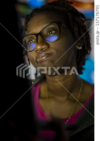 Close up of woman staring at laptop screen, feeling tired while doing homework. African american teenager struggling to stay focused while reading school books, battling fatigue and distractions Close up of woman staring at laptop screen, feeling tired while doing homework. African american teenager struggling to stay focused while reading school books, battling fatigue and distractions 137176791