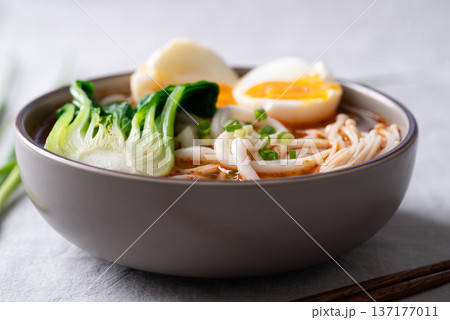 Spicy Udon Noodle Soup topped with Bok Choy, Enoki Mushrooms and Soft Boiled Egg 137177011