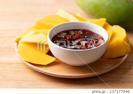 Fresh sliced mangoes eating with Thai sweet fish sauce (Nam Pla Wan) 137177046