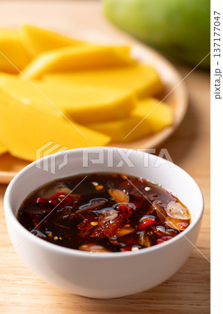 Fresh sliced mangoes eating with Thai sweet fish sauce (Nam Pla Wan) 137177047