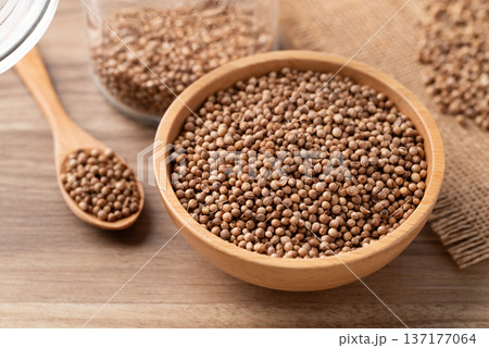 Coriander seeds in a wooden bowl and spoon on a wooden background, Thai food ingredients Coriander seeds in a wooden bowl and spoon on a wooden background, Thai food ingredients 137177064