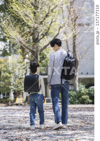 並んで歩く小学3年生の男の子と30代の父親 並んで歩く小学3年生の男の子と30代の父親 137177310
