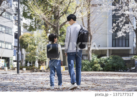 並んで歩く小学3年生の男の子と30代の父親 137177317