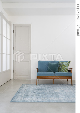 リビングルーム　イメージ　白い壁の部屋に置かれたブルーのソファ 137178144