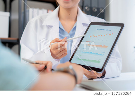 Asian nutritionist showing AI health analysis graph on tablet to man patient. Asian nutritionist showing AI health analysis graph on tablet to man patient. 137180264