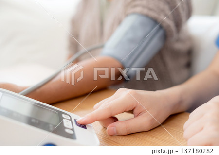 Asian woman nurse measuring blood pressure senior patient. 137180282