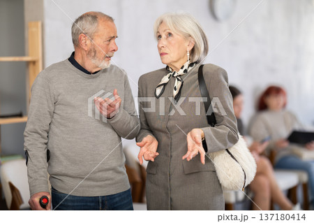 Elderly woman talking to senior man in clinic waiting area 137180414