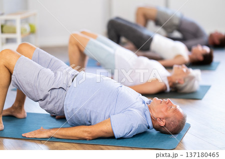 Elderly man doing pilates in group 137180465