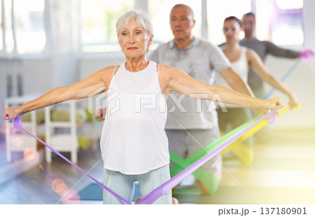 Elderly woman exercises with pilates band 137180901