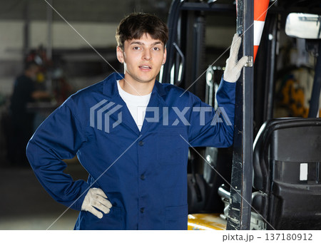 Young male worker working on forklift at metallurgical plant Young male worker working on forklift at metallurgical plant 137180912