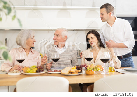 Elderly parents with adult children enjoying family dinner 137181103