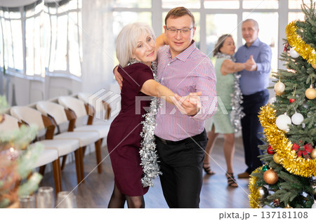 Aged couple during celebration Christmas and New Year dancing cha-cha-cha dance at ballroom 137181108
