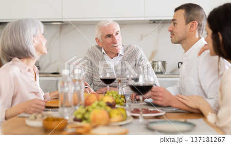 Senior parents and young couple sitting at table drinking wine and having conversation 137181267