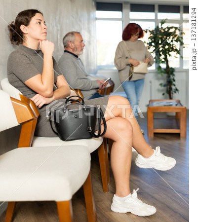 Group of positive people of different ages sitting in queue at hall of civil service building or medical clinic 137181294