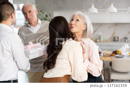 Elderly mother kissing adult daughter coming to parents house Elderly mother kissing adult daughter coming to parents house 137181359