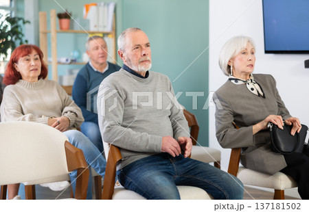 Mature people are listening to lecture in auditorium. Group psychological interaction, practical classes in psychology 137181502