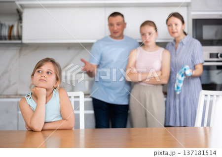Frustrated tween girl listening to disgruntled parents reprimand Frustrated tween girl listening to disgruntled parents reprimand 137181514