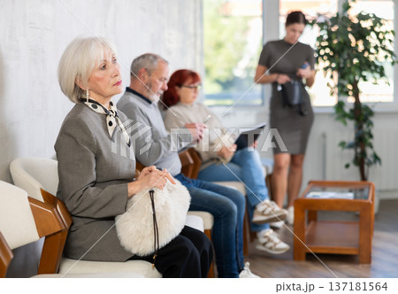 Elderly woman waiting in line during visit to medical center Elderly woman waiting in line during visit to medical center 137181564