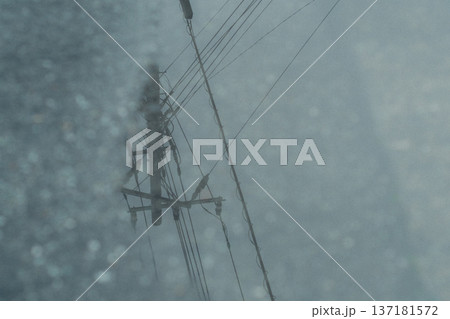 雨の中にそびえ立つ電柱 137181572
