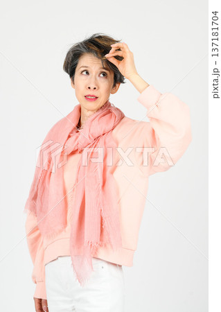 白バックで左手で白髪を気にするしぐさをする50代女性 白バックで左手で白髪を気にするしぐさをする50代女性 137181704