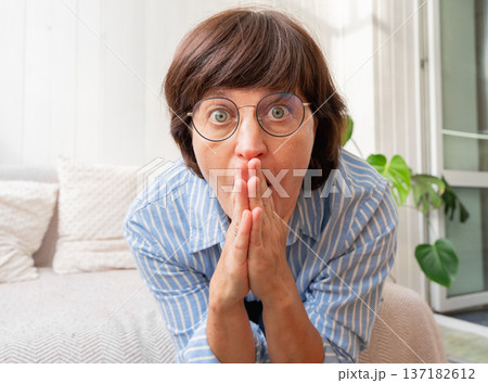 Surprised caucasian adult female with glasses in blue striped shirt Surprised caucasian adult female with glasses in blue striped shirt 137182612