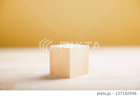 A building block concept, business begins with a foundational idea like this wooden cube, the solid first step for a successful business plan against a yellow background A building block concept, business begins with a foundational idea like this wooden cube, the solid first step for a successful business plan against a yellow background 137182936