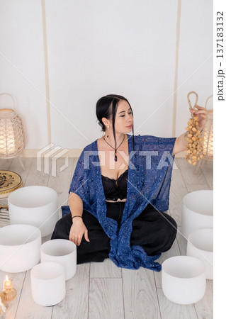 Sound meditation. Flow chimes. Woman playing crystal singing bowls enjoying noise therapy wellness retreat candles for healing treatment. Sound meditation. Flow chimes. Woman playing crystal singing bowls enjoying noise therapy wellness retreat candles for healing treatment. 137183132