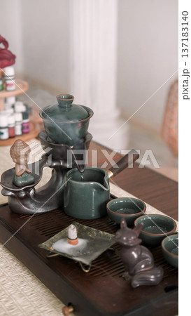 Tea service. Fresh beverage. Table with tea-board pouring water chinese hot steam ceremony incense for drinking figurine. 137183140