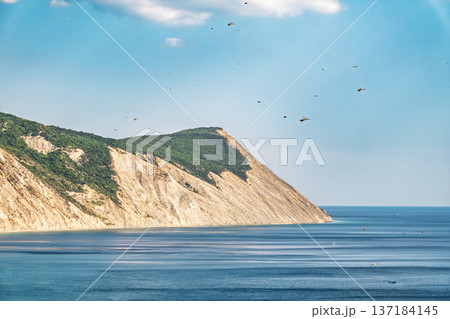 High mountain slopes to the Black Sea coast in Anapa, Russia. Coastline in sunset, beautiful sea scenery. Anapa coast landscape, high cliff 137184145