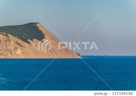High mountain slopes to the Black Sea coast in Anapa, Russia. Coastline in sunset, beautiful sea scenery. Anapa coast landscape, high cliff High mountain slopes to the Black Sea coast in Anapa, Russia. Coastline in sunset, beautiful sea scenery. Anapa coast landscape, high cliff 137184148