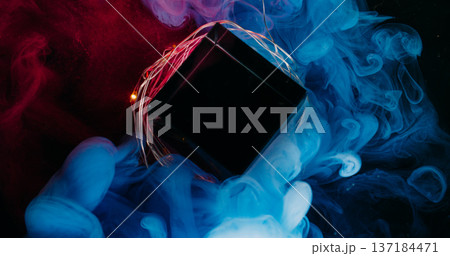 Colorful fog. Diamond frame. Blue red purple fume blend on glass crystal cube. Light garland abstract defocused ink black background. Colorful fog. Diamond frame. Blue red purple fume blend on glass crystal cube. Light garland abstract defocused ink black background. 137184471