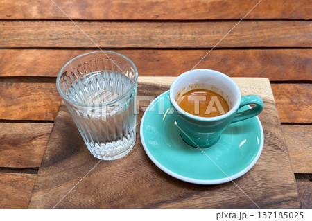 Beautiful unicorn latte art and a shot of espresso served on a wooden tray in a cafe. Beautiful unicorn latte art and a shot of espresso served on a wooden tray in a cafe. 137185025
