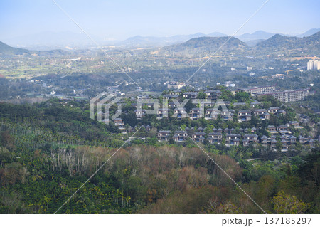 Aerial view of Sanya city with a sea bay surrounded by mountains on Hainan Island in China Aerial view of Sanya city with a sea bay surrounded by mountains on Hainan Island in China 137185297