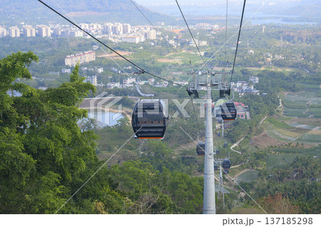 Cable car cabins above the forest and valley near the city of Sanya on Hainan Island in China 137185298